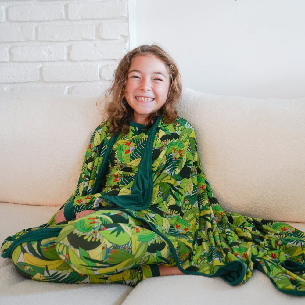 Person sitting on a couch with a green patterned blanket