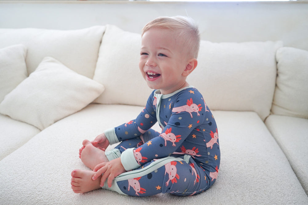 a child wearing an axolotl printed zip-up pajama